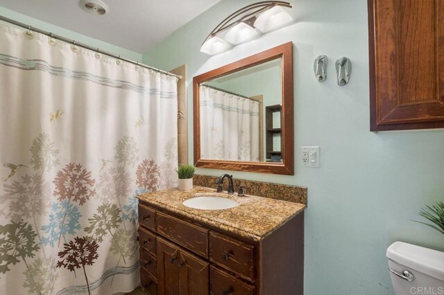 5566 Streamview Dr, San Diego, CA 92105 - full bathroom featuring toilet, a shower with shower curtain, and vanity