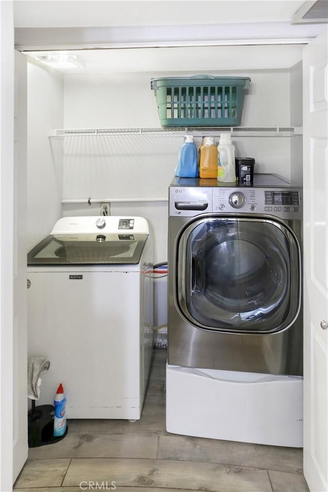 11818 Mount Harvard Ct, Rancho Cucamonga, CA 91737 - laundry room with washing machine and clothes dryer and wood finished floors