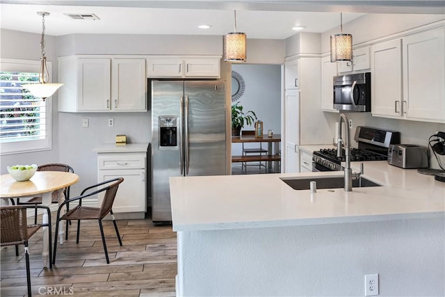 11818 Mount Harvard Ct, Rancho Cucamonga, CA 91737 - kitchen featuring appliances with stainless steel finishes, light wood-style floors, light countertops, a peninsula, and recessed lighting