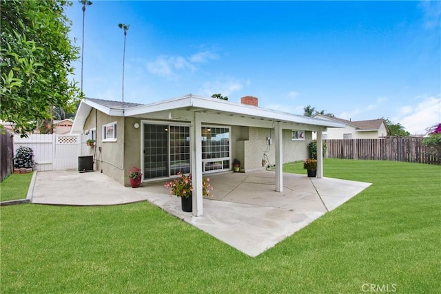 rear view of house with a fenced backyard, stucco siding, a chimney, a patio area, and a lawn