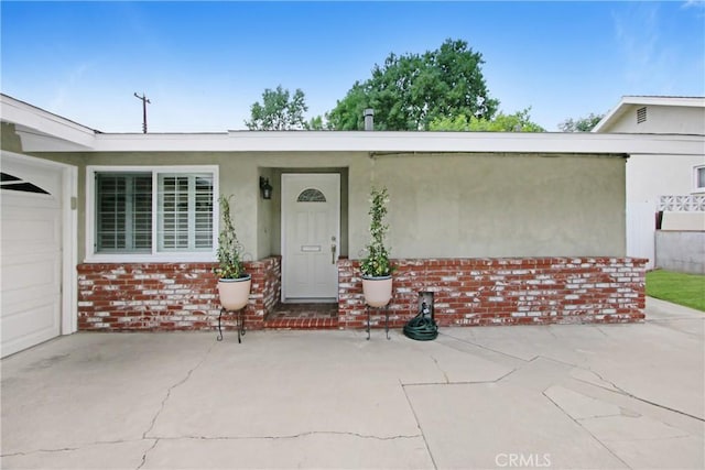 property entrance featuring brick siding and stucco siding