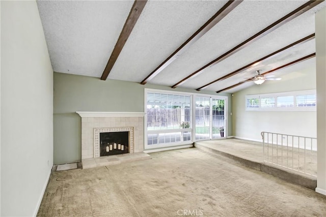 unfurnished living room with carpet floors, baseboards, vaulted ceiling with beams, and a tile fireplace