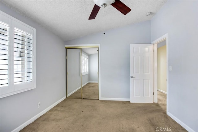 unfurnished bedroom with carpet floors, a textured ceiling, and lofted ceiling