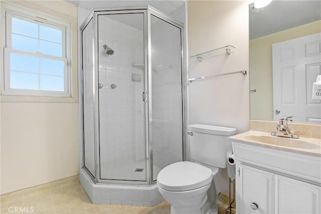 bathroom featuring vanity, toilet, and a shower stall
