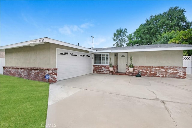 view of front facade featuring a front lawn, stucco siding, brick siding, an attached garage, and driveway