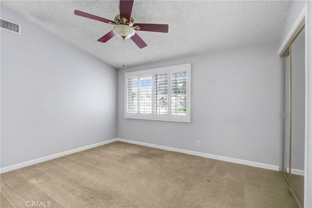 unfurnished bedroom featuring carpet flooring, a textured ceiling, visible vents, and baseboards