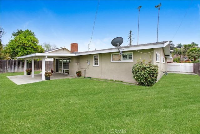 rear view of property featuring a lawn, a fenced backyard, and a patio area