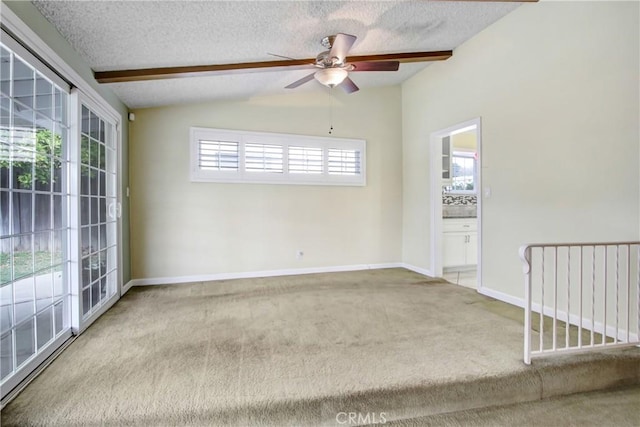 carpeted empty room featuring baseboards, a textured ceiling, vaulted ceiling, and ceiling fan