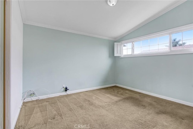 carpeted empty room featuring baseboards, crown molding, and lofted ceiling