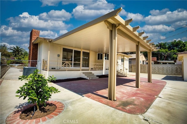 exterior space with a patio, fence, stucco siding, and a chimney