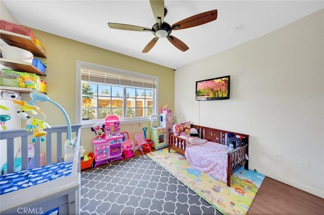 bedroom featuring baseboards, a ceiling fan, and wood finished floors
