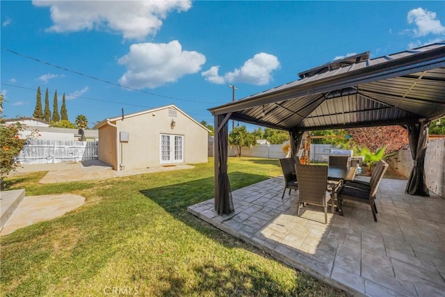 view of patio with a gazebo, a fenced backyard, french doors, and outdoor dining area