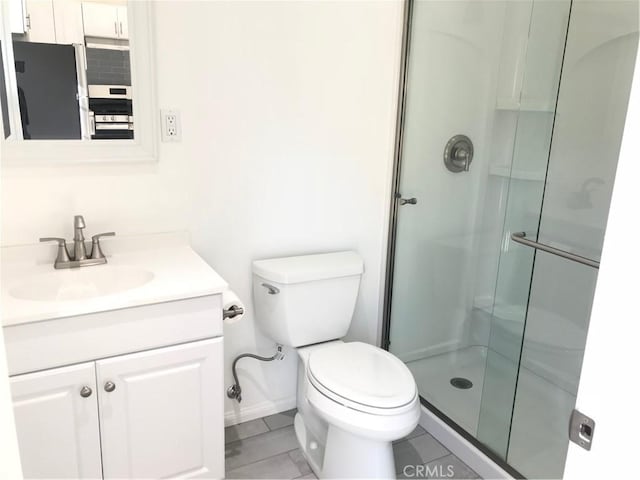 full bathroom featuring a shower stall, vanity, baseboards, tile patterned floors, and toilet