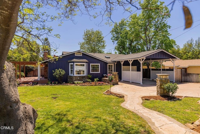 single story home featuring board and batten siding, a deck, fence, and a front lawn