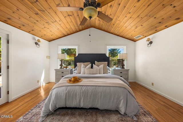 bedroom featuring visible vents, multiple windows, wood finished floors, and lofted ceiling