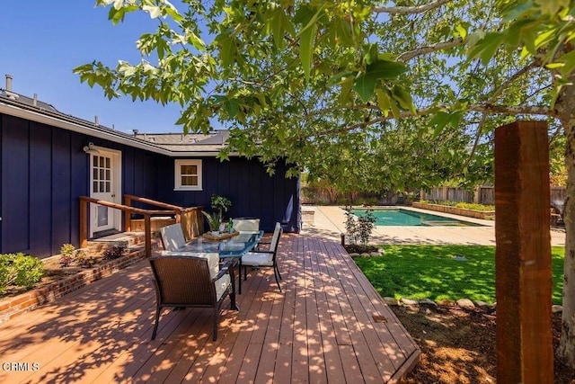 deck with a fenced in pool, fence, and outdoor dining space