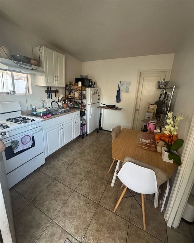 2043 City View Ave, Los Angeles, CA 90033 - kitchen with white appliances, white cabinetry, dark tile patterned flooring, exhaust hood, and a sink