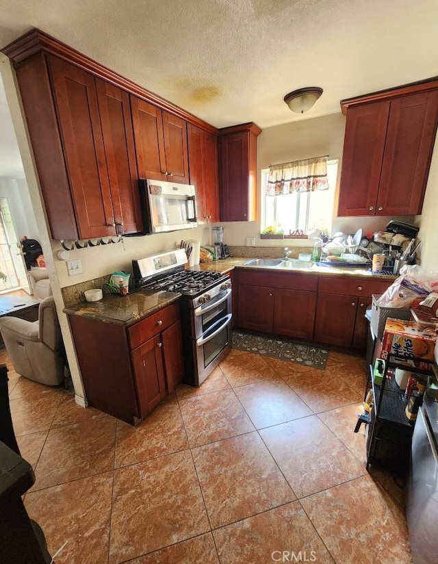 2043 City View Ave, Los Angeles, CA 90033 - kitchen featuring appliances with stainless steel finishes, a sink, a textured ceiling, dark countertops, and light tile patterned flooring