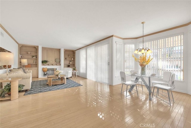17527 Mondino Dr, Rowland Heights, CA 91748 - living area featuring built in shelves, ornamental molding, wood finished floors, a chandelier, and baseboards