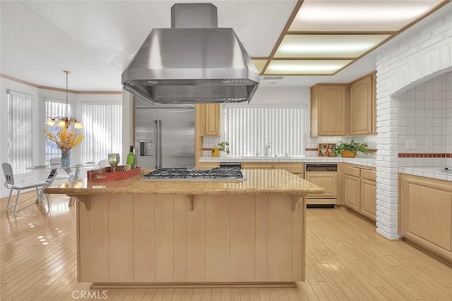 17527 Mondino Dr, Rowland Heights, CA 91748 - kitchen featuring island exhaust hood, stainless steel appliances, a center island, decorative backsplash, and light wood finished floors