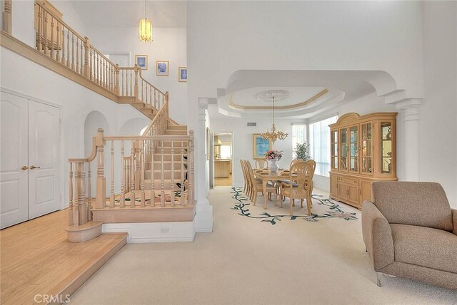 17527 Mondino Dr, Rowland Heights, CA 91748 - carpeted living room featuring stairs, a raised ceiling, a chandelier, and a towering ceiling