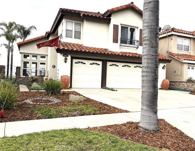 mediterranean / spanish home with a tile roof, a garage, stucco siding, concrete driveway, and a balcony