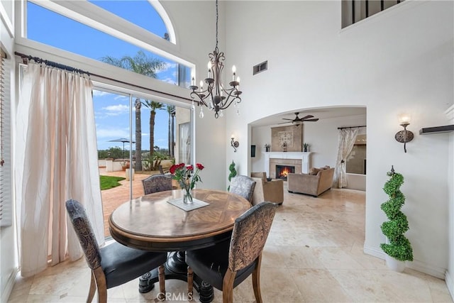 1081 Vista Lomas Ln, Corona, CA 92882 - dining room featuring visible vents, a warm lit fireplace, and a high ceiling