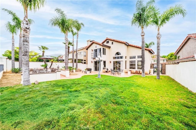 1081 Vista Lomas Ln, Corona, CA 92882 - back of property featuring a yard, a tiled roof, a patio area, stucco siding, and a fenced backyard