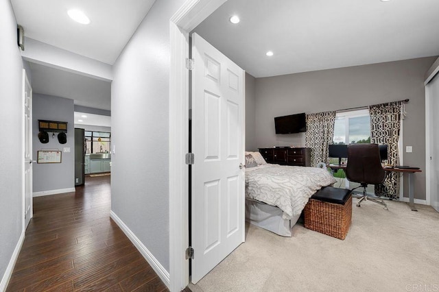 bedroom with baseboards, recessed lighting, wood finished floors, and multiple windows