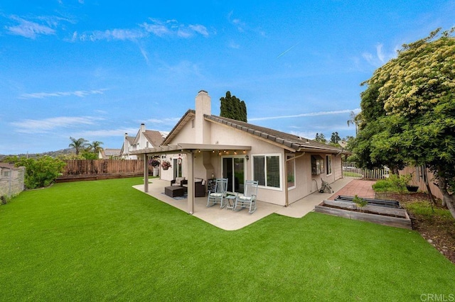 rear view of house with a lawn, a fenced backyard, and a patio