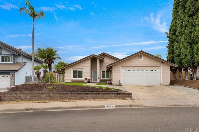 view of front of house with concrete driveway, an attached garage, and fence