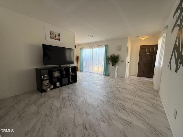 unfurnished living room featuring baseboards and marble finish floor