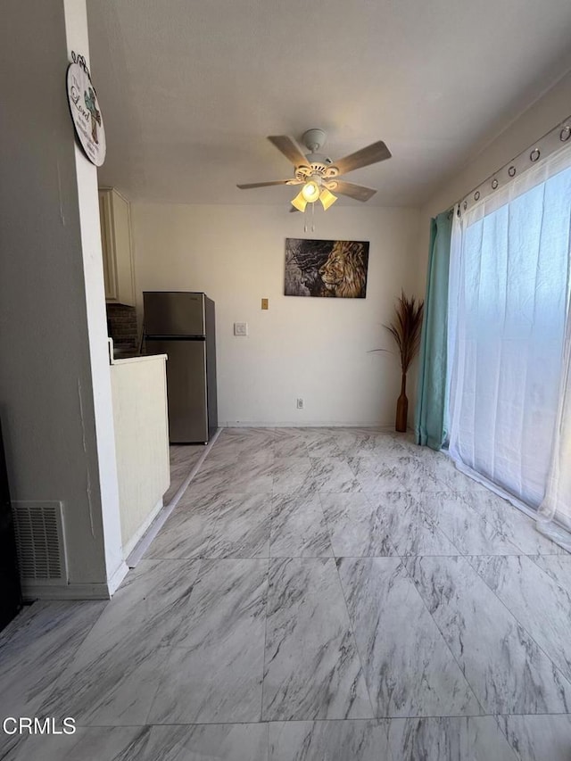 unfurnished living room featuring ceiling fan, visible vents, and marble finish floor