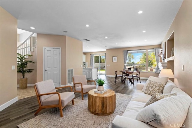 living area featuring visible vents, recessed lighting, baseboards, and wood finished floors