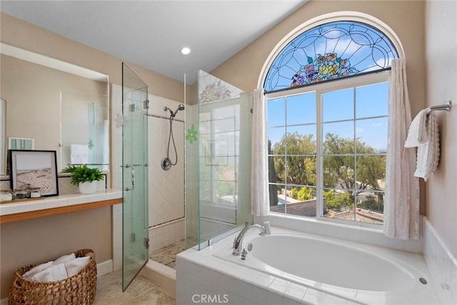 full bath with a healthy amount of sunlight, a stall shower, and a garden tub