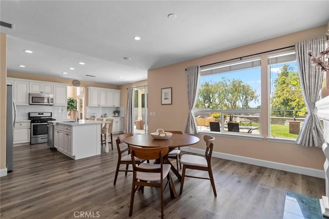 dining area with recessed lighting, dark wood finished floors, baseboards, and visible vents