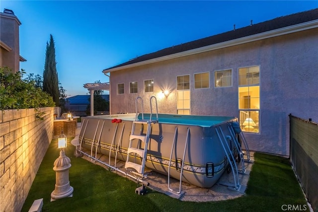 back of property featuring a fenced in pool, a fenced backyard, stucco siding, and a pergola