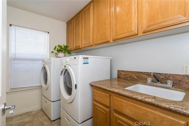 washroom with separate washer and dryer, a sink, and cabinet space