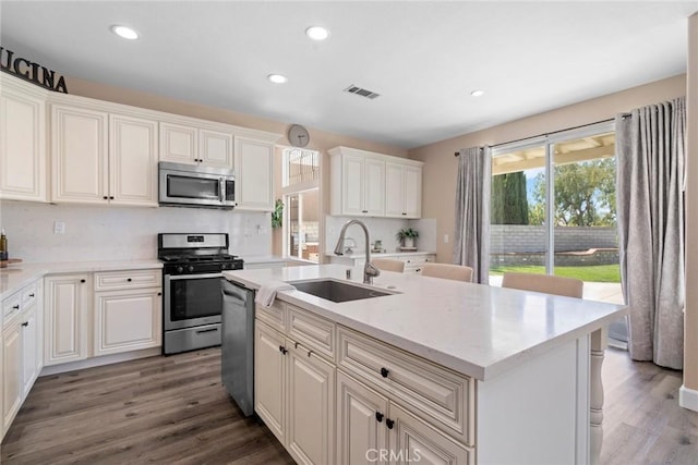 kitchen featuring a sink, stainless steel appliances, wood finished floors, and visible vents