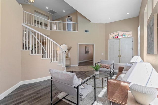 living room with baseboards, wood finished floors, visible vents, and stairway