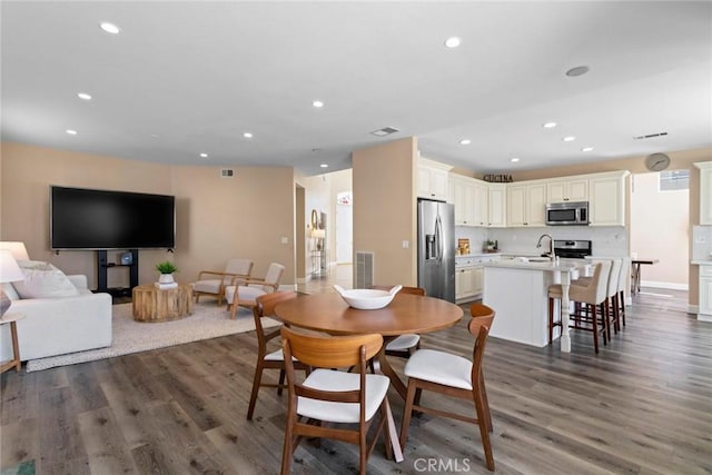 dining space with recessed lighting, baseboards, visible vents, and wood finished floors