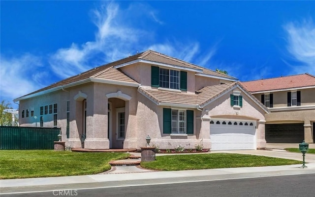 view of front of home with driveway, fence, a tile roof, and stucco siding