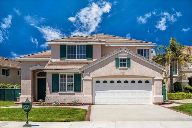 traditional-style home featuring concrete driveway, a garage, fence, and stucco siding