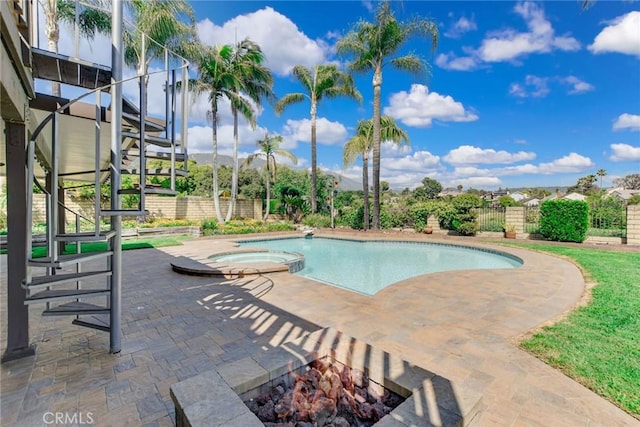 view of swimming pool with a patio area, fence, and a pool with connected hot tub
