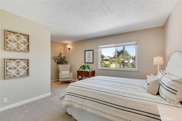 bedroom with baseboards, carpet flooring, and a textured ceiling