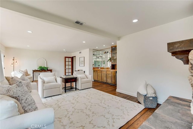living room featuring recessed lighting, baseboards, visible vents, and wood finished floors