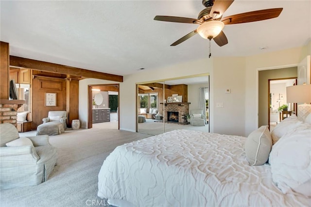 bedroom with carpet flooring, ceiling fan, and a fireplace