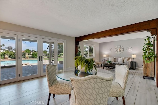 dining space featuring baseboards, french doors, and a textured ceiling