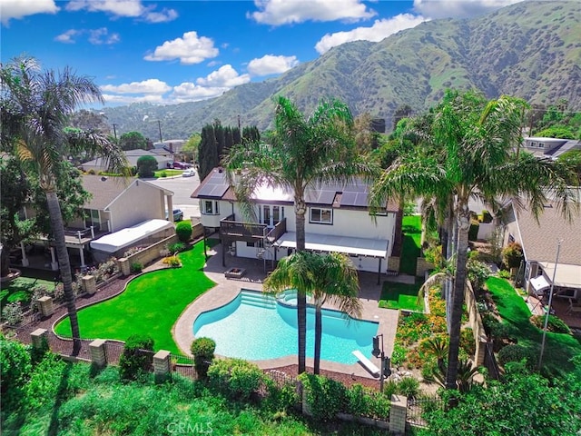 pool featuring a yard, a patio, a mountain view, and a fenced backyard