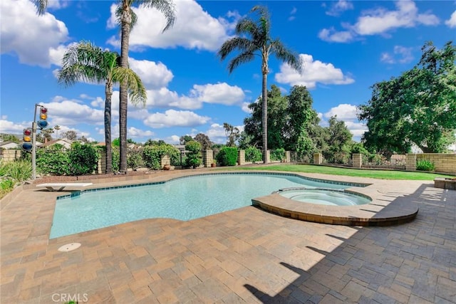 view of pool featuring a fenced backyard, a diving board, a pool with connected hot tub, and a patio area